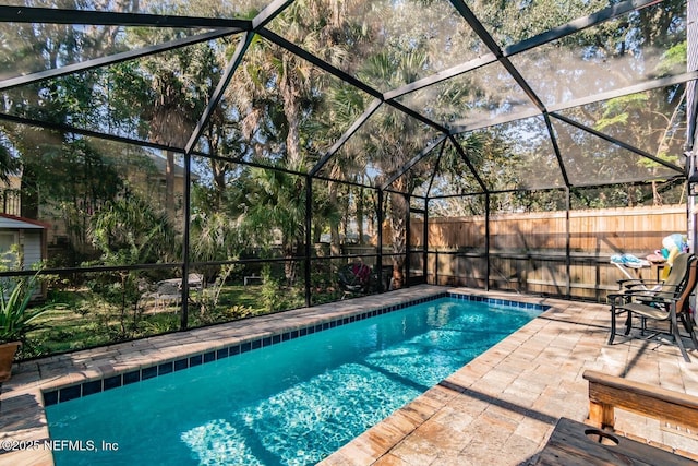 view of pool featuring glass enclosure and a patio area