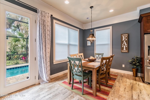 dining room with light hardwood / wood-style flooring and crown molding