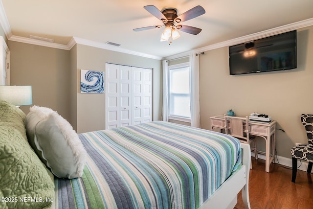 bedroom featuring ceiling fan, a closet, dark hardwood / wood-style flooring, and ornamental molding