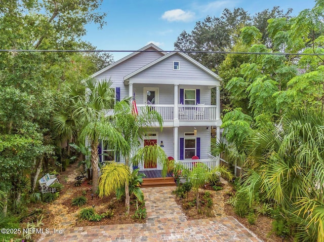 raised beach house with a balcony and a porch