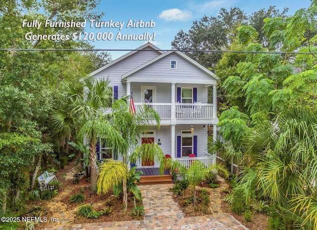 beach home featuring covered porch and a balcony