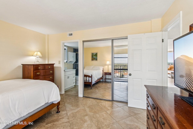 tiled bedroom with ensuite bathroom and a closet