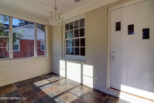 unfurnished sunroom with a chandelier and wooden ceiling