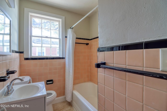 full bathroom with vanity, tile patterned flooring, toilet, shower / bath combo with shower curtain, and tile walls