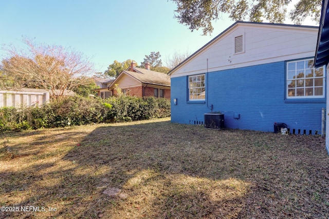 exterior space featuring central air condition unit and a lawn