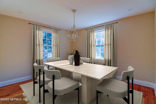 dining space featuring hardwood / wood-style flooring and a chandelier