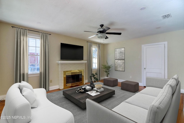 living room with ceiling fan, a fireplace, and hardwood / wood-style floors