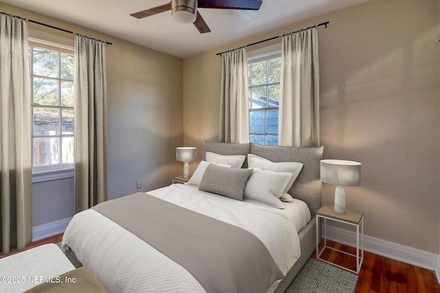 bedroom with multiple windows, ceiling fan, and dark wood-type flooring