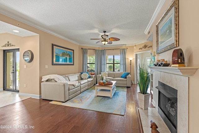 living room with ceiling fan, ornamental molding, and light hardwood / wood-style flooring