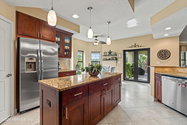 kitchen featuring pendant lighting, french doors, ceiling fan, tasteful backsplash, and stainless steel appliances