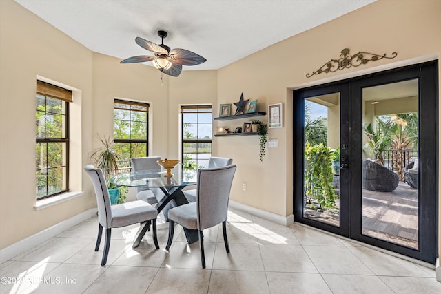 tiled dining space with ceiling fan, plenty of natural light, and french doors