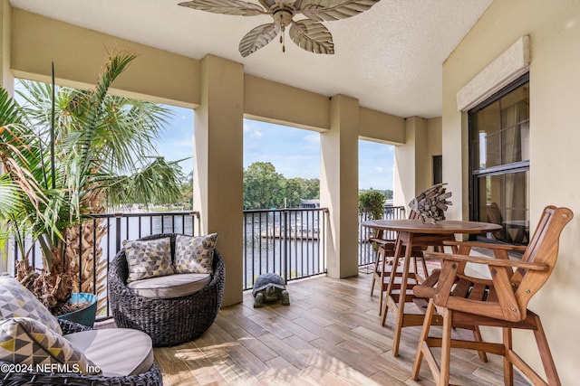 balcony with a water view and ceiling fan