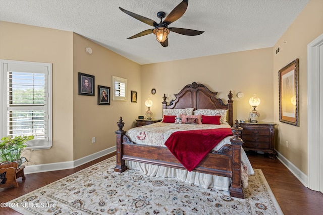 bedroom with ceiling fan, dark hardwood / wood-style flooring, and a textured ceiling