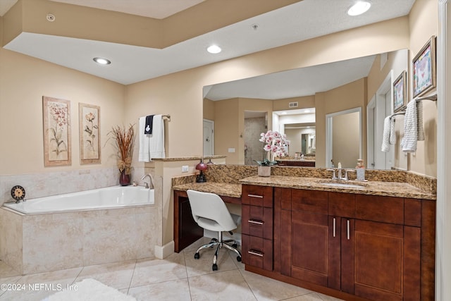 bathroom featuring tiled bath, tile patterned flooring, and vanity