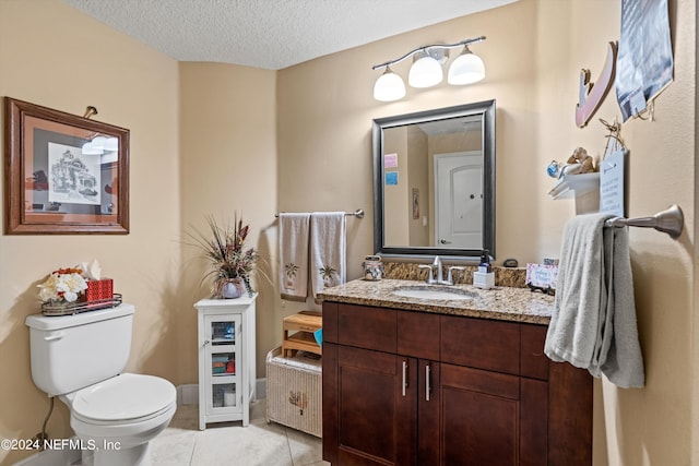 bathroom featuring tile patterned floors, vanity, a textured ceiling, and toilet