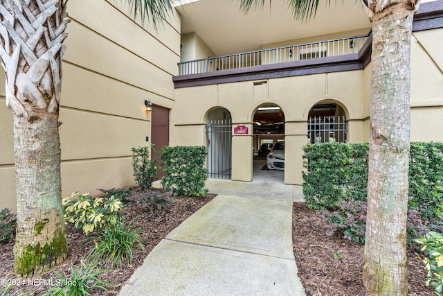 doorway to property featuring a carport and a balcony