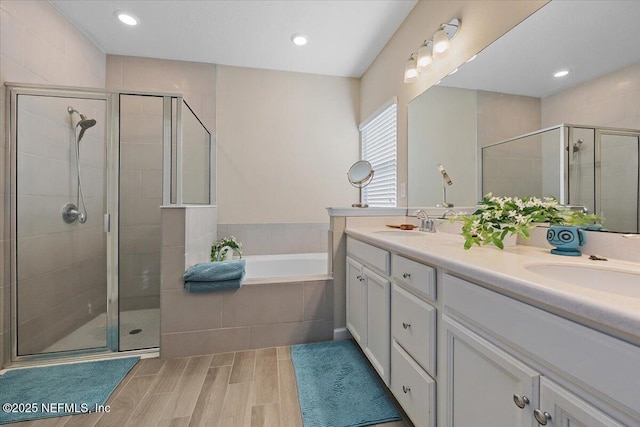 bathroom featuring shower with separate bathtub and vanity