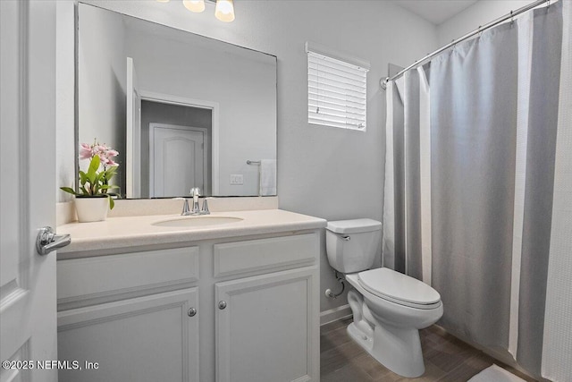 bathroom with hardwood / wood-style floors, vanity, and toilet