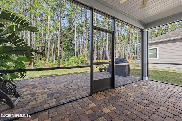 unfurnished sunroom with ceiling fan