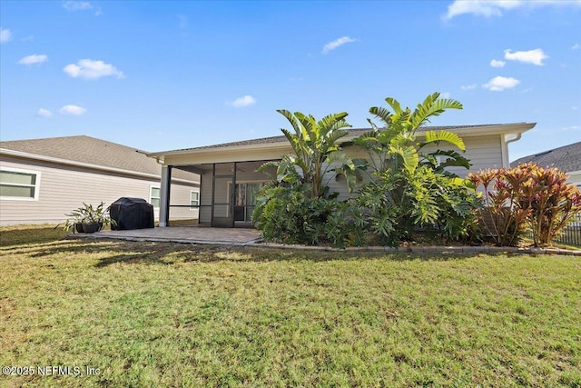 rear view of house featuring a lawn and a sunroom