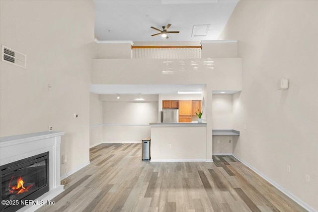 unfurnished living room featuring ceiling fan and light hardwood / wood-style flooring