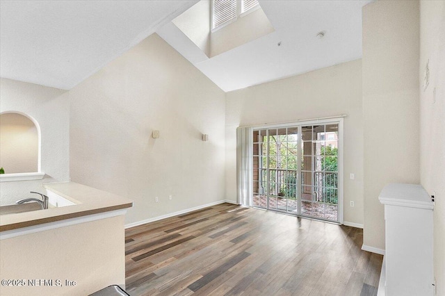 unfurnished living room featuring hardwood / wood-style floors and a high ceiling