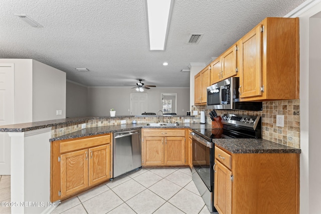 kitchen featuring light tile patterned flooring, appliances with stainless steel finishes, kitchen peninsula, and sink