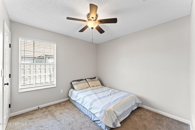 bedroom with light colored carpet, a textured ceiling, and ceiling fan