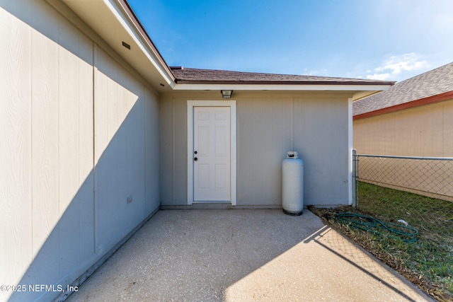 view of exterior entry with a patio area