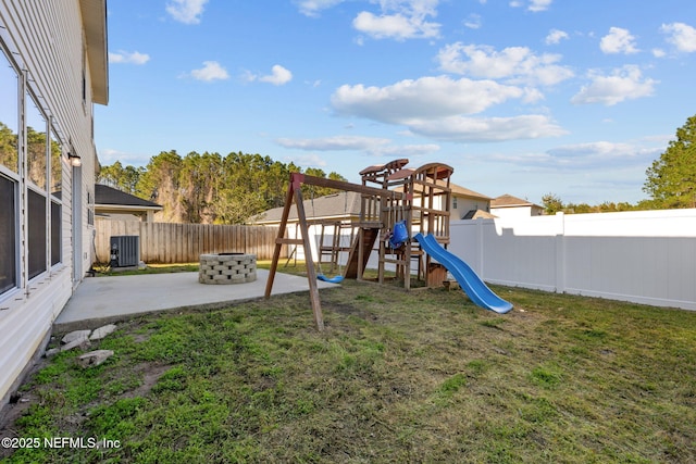 view of jungle gym with central AC, a yard, a patio, and a fire pit