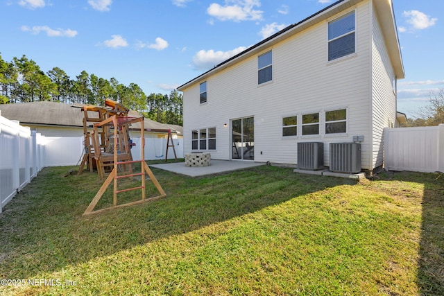 back of property with a lawn, a patio area, a playground, and central AC