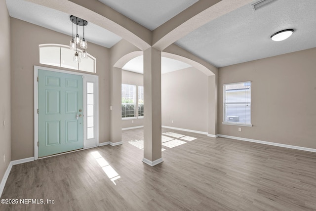 foyer with hardwood / wood-style floors and a textured ceiling