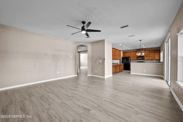 unfurnished living room featuring ceiling fan and light hardwood / wood-style flooring