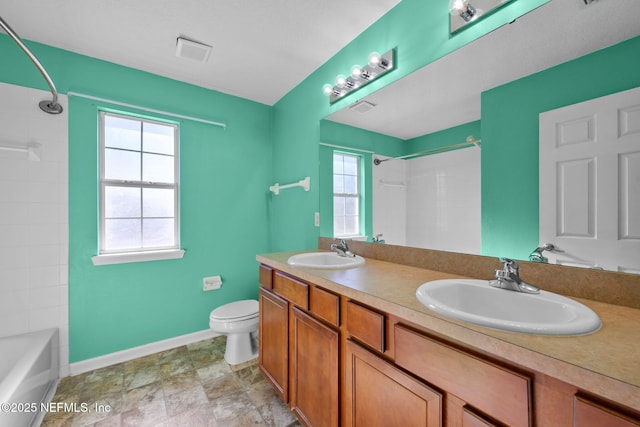 full bathroom featuring washtub / shower combination, vanity, and toilet