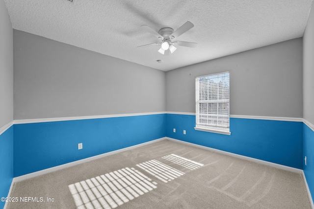 carpeted empty room featuring ceiling fan and a textured ceiling