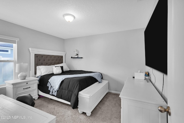 bedroom with a textured ceiling and light carpet