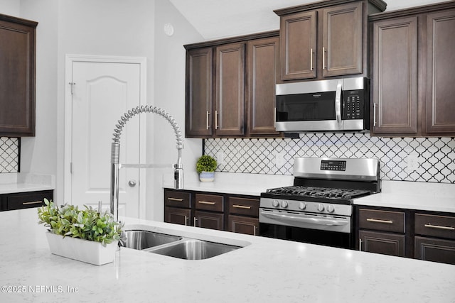 kitchen featuring appliances with stainless steel finishes, dark brown cabinetry, and backsplash