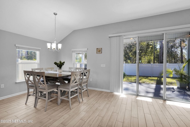 dining area featuring light wood-type flooring, lofted ceiling, and an inviting chandelier