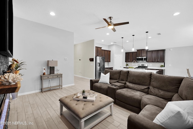 living room with light hardwood / wood-style flooring and ceiling fan