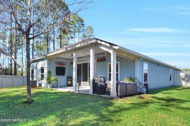 back of property with a lawn and a patio area