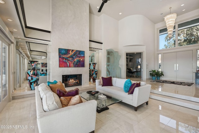 living room featuring a fireplace, light tile patterned floors, and a towering ceiling