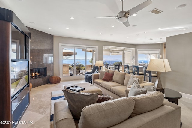 living room with ceiling fan and a large fireplace