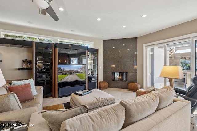 living room with ceiling fan, a premium fireplace, and a healthy amount of sunlight