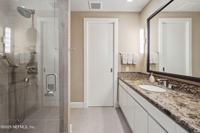 bathroom featuring vanity and a shower with door