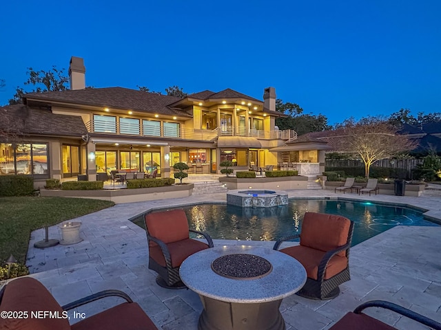 view of pool with a patio area, an outdoor fire pit, and an in ground hot tub