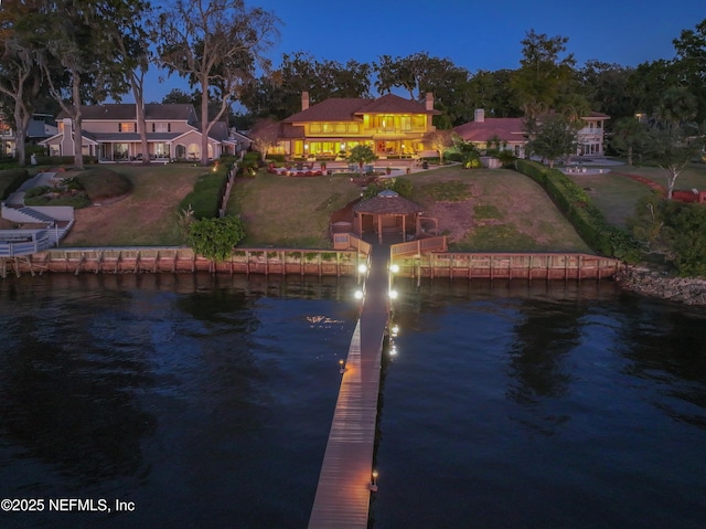 rear view of property with a water view, a gazebo, and a yard