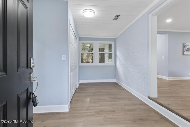 hallway featuring light wood-type flooring, crown molding, and wooden ceiling