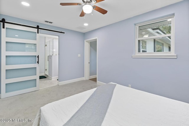 carpeted bedroom featuring ceiling fan and a barn door