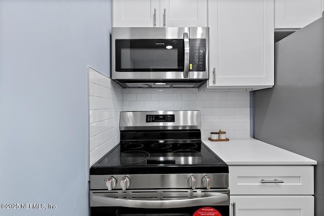 kitchen featuring white cabinets, appliances with stainless steel finishes, and tasteful backsplash