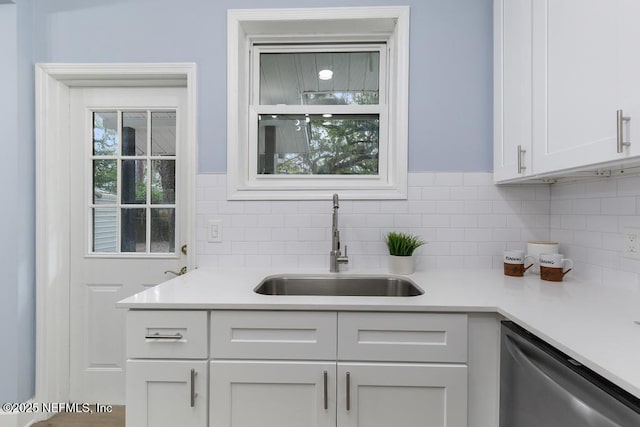 bar featuring sink, white cabinets, and dishwasher